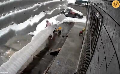 (ویدئو) ریزش وحشتناک انبوه برف از پشت‌بام روی یک زن