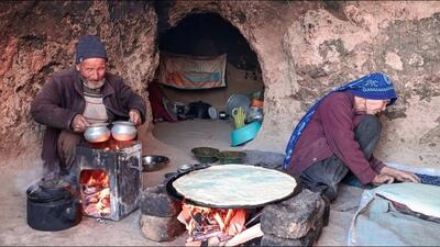 (ویدئو) فرآیند دیدنی پخت نان و خورشت تخم مرغ به روش یک زوج مسن غارنشین افغان