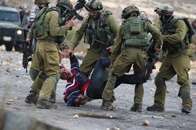 تصاویر 16+ | صهیونیست ها با تانک از روی یک فلسطینی گذشتند | فقط دست دستبندزده او سالم مانده است