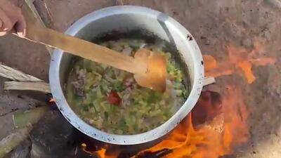 (ویدئو) نمایی از پخت یک غذای ساده با سیب زمینی و گوجه توسط یک زوج غارنشین افغان