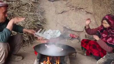 (ویدئو) روش عالی و جالب یک زوج غارنشین افغان در پخت مرغ و سبزیجات روی ساج
