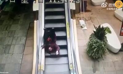 لحظه  سقوط عجیب یک زن از پله برقی +ویدئو