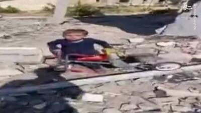 فیلم/ تلاش پسربچه فلسطینی برای بیرون آوردن سه چرخه اش از زیر آوار