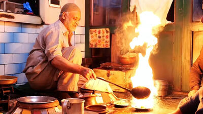 (ویدئو) غذای خیابانی در هند؛ پخت یک غذای محلی با گوشت، پاچه و کباب لوله ای