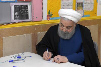 عکس | حدیث معنادار در کنار حسن روحانی هنگام نوشتن برگه رای در انتخابات