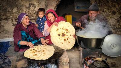 (ویدئو) فرآیند پخت ماش پلو توسط زوج غارنشین مسن افغانستانی
