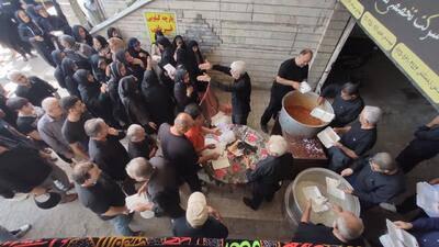 توزیع غذای نذری بین عزاداران حسینی در آستانه اشرفیه