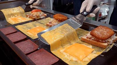 غذای خیابانی در کره جنوبی؛ پخت ساندویچ با تخم مرغ، پنیر و کالباس (فیلم)