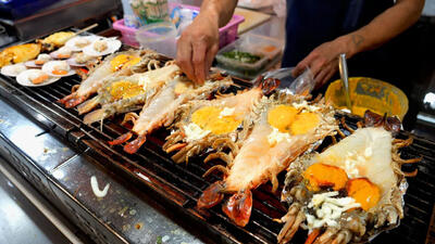(ویدئو) غذای خیابانی در تایلند؛ پخت انواع غذا با خرچنگ و میگو در بانکوک